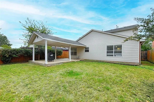 a view of a house with backyard and a tree
