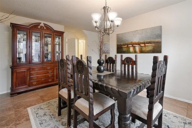 a view of a dining room with furniture a chandelier and wooden floor
