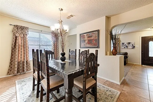 a view of a dining room with furniture and chandelier