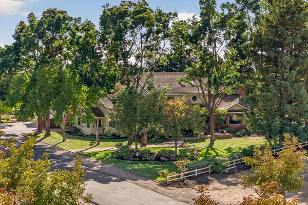 a front view of a house with a yard and trees