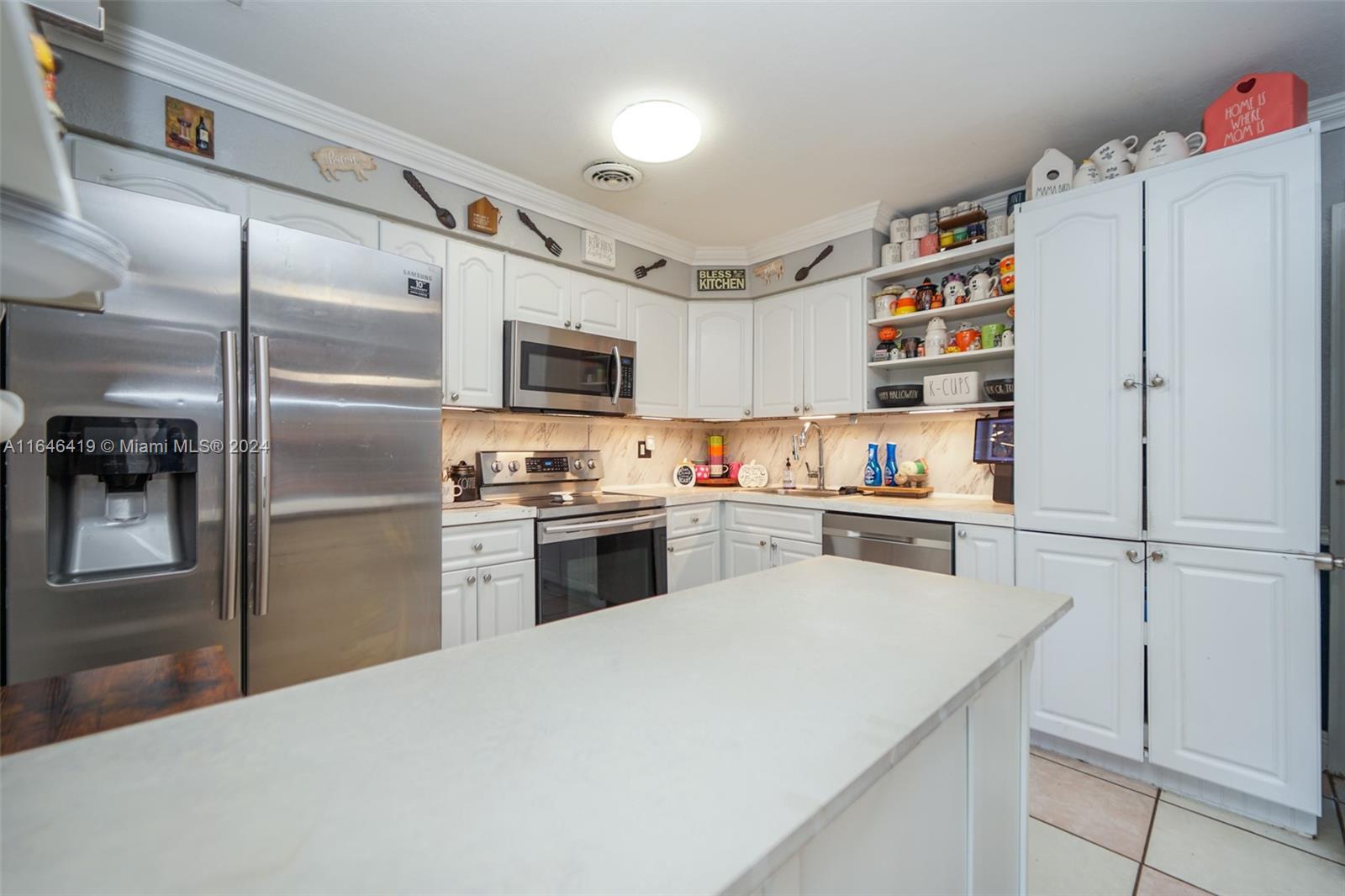 18400 Northeast 7th Court North Miami Beach, FL 33179 - Photo 2 of 24 a kitchen with granite countertop stainless steel appliances and refrigerator