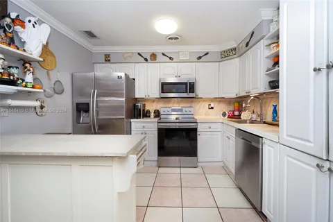 a kitchen with stainless steel appliances a refrigerator sink and microwave