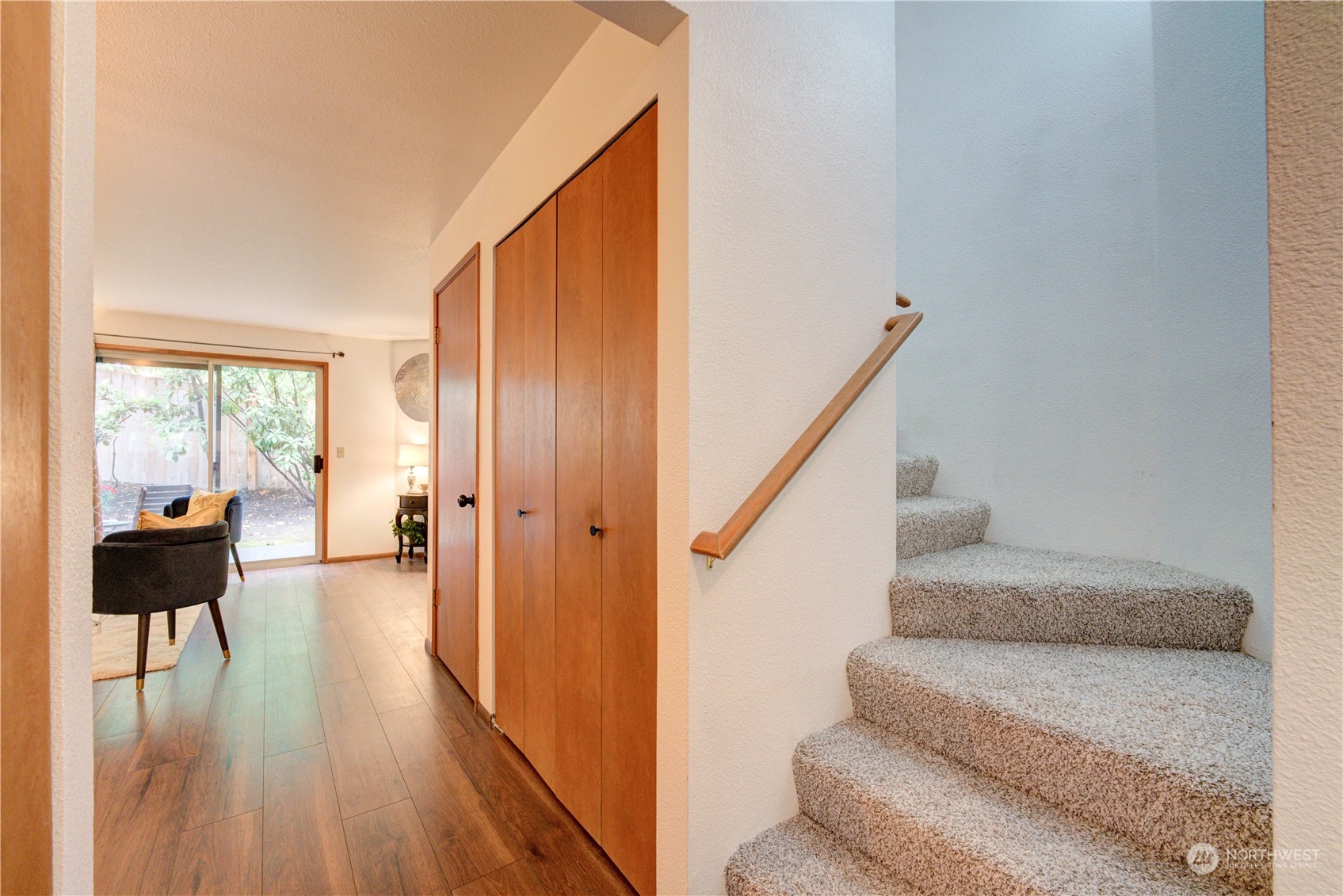 18910 Bothell Everett Highway, Unit J3 Bothell, WA 98012 - Photo 12 of 33 a view of staircase and living room with wooden floor and furniture
