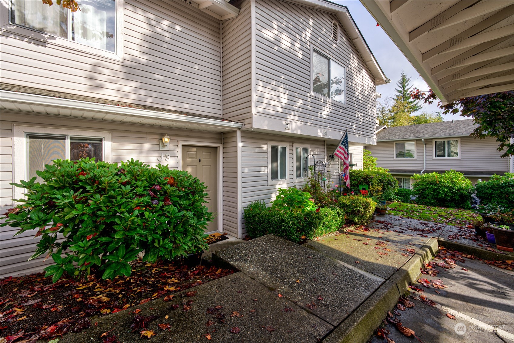 18910 Bothell Everett Highway, Unit J3 Bothell, WA 98012 - Photo 2 of 33 a view of a backyard with plants and a patio