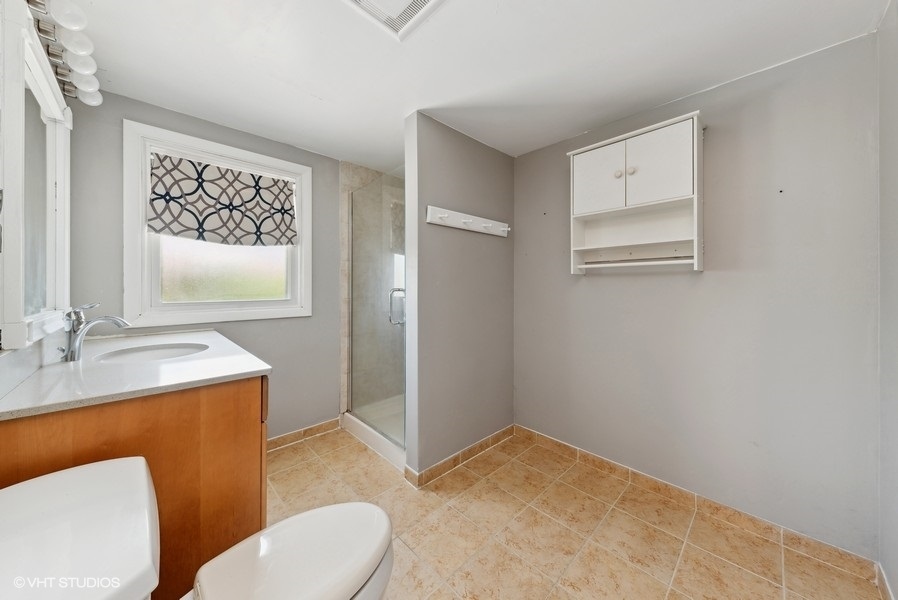 605 Revere Road Glenview, IL 60025 - Photo 12 of 18 a bathroom with a toilet a sink and mirror
