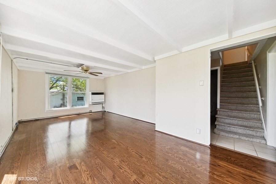 605 Revere Road Glenview, IL 60025 - Photo 7 of 18 a view of an empty room with wooden floor and a window