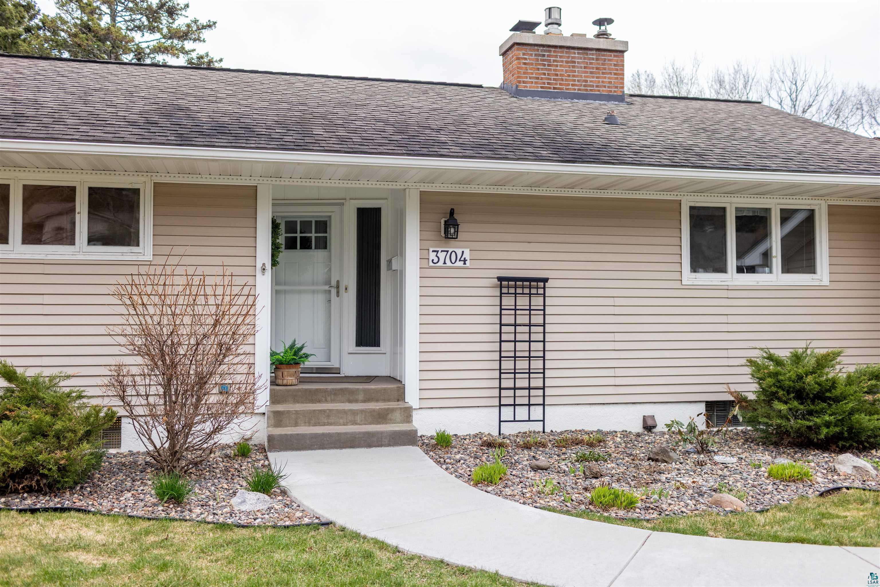 3704 Greysolon Road Duluth, MN 55804 - Photo 51 of 51 Ranch-style residence featuring horizontal siding, a gabled asphalt shingle roof, and a prominent brick chimney
