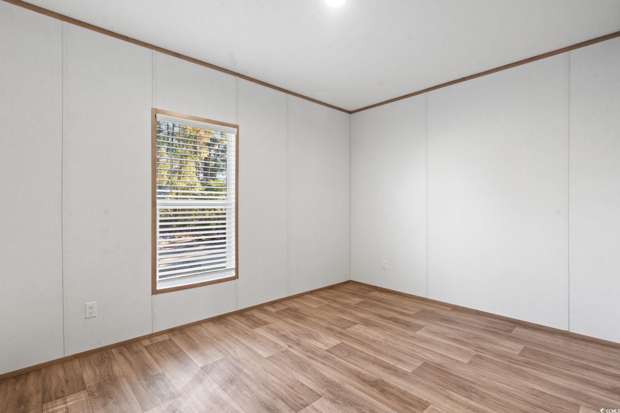 4448 Flat Bay Circle Myrtle Beach, SC 29588 - Photo 11 of 30 Empty room with light wood-style floors and ornamental molding