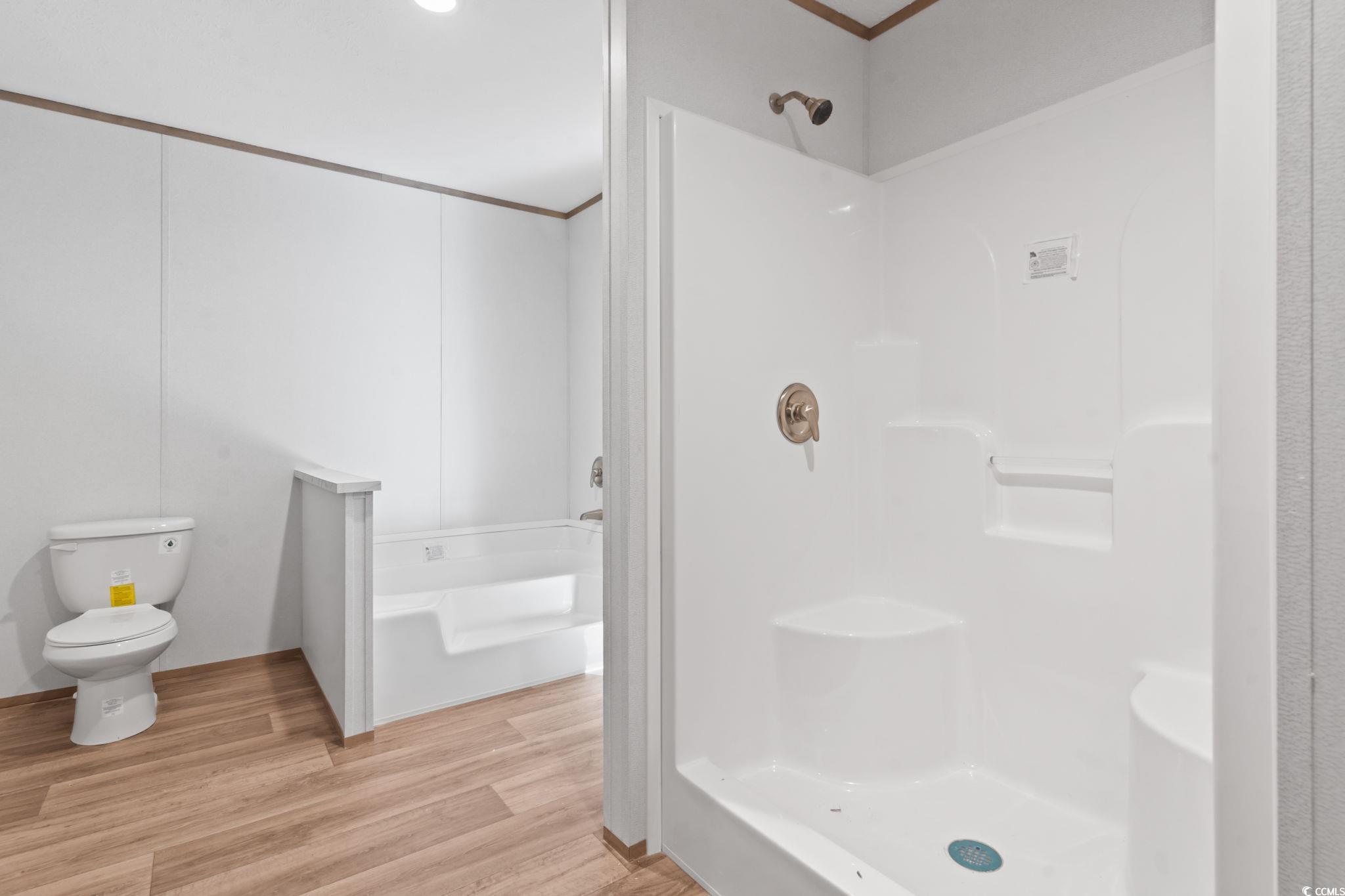 4448 Flat Bay Circle Myrtle Beach, SC 29588 - Photo 23 of 30 Bathroom with light wood-style flooring, a stall shower, ornamental molding, and a garden tub