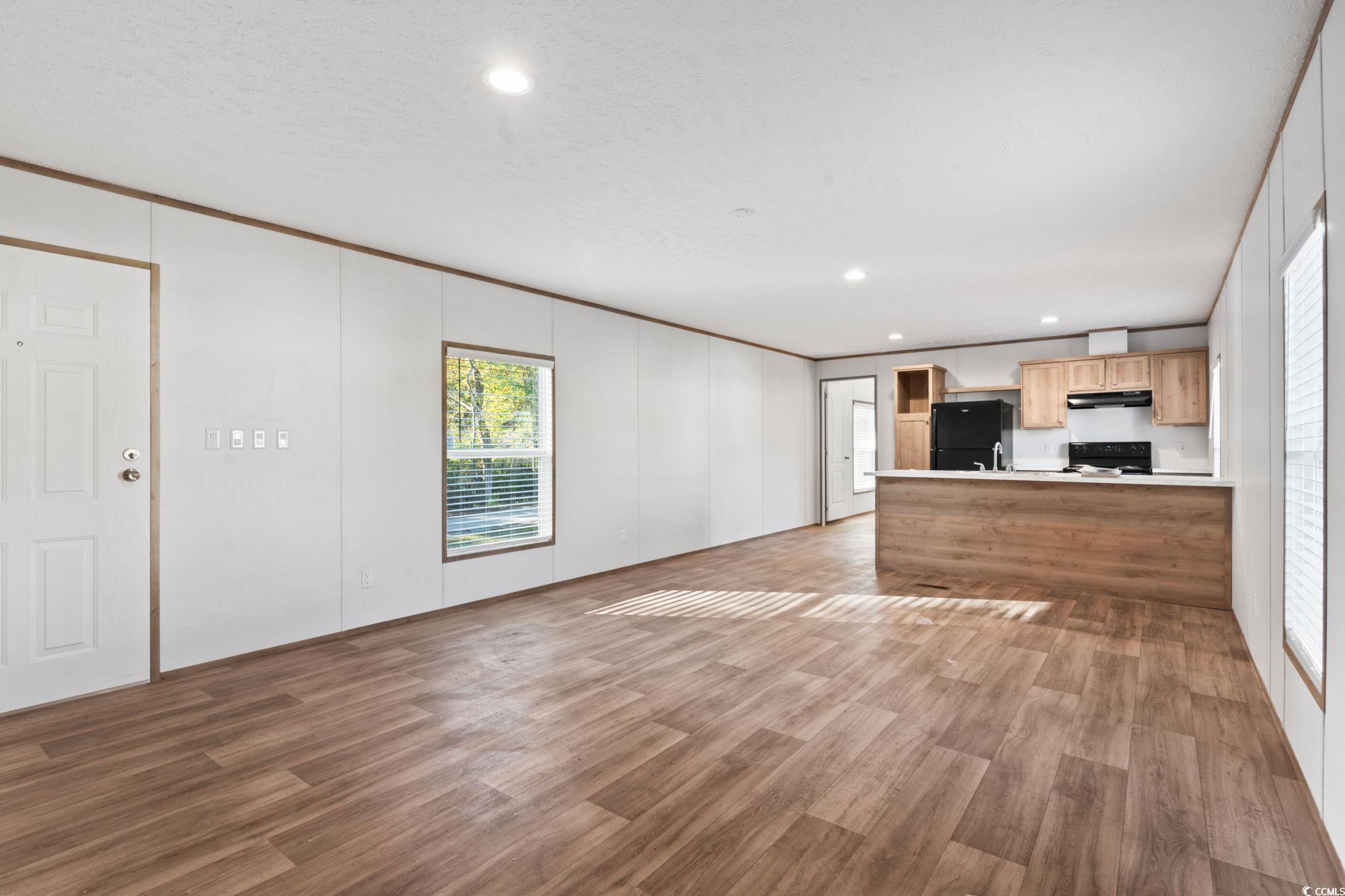 4448 Flat Bay Circle Myrtle Beach, SC 29588 - Photo 26 of 30 Unfurnished living room featuring crown molding, light wood-style flooring, and recessed lighting