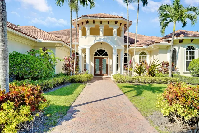 a view of a house with a yard and potted plants