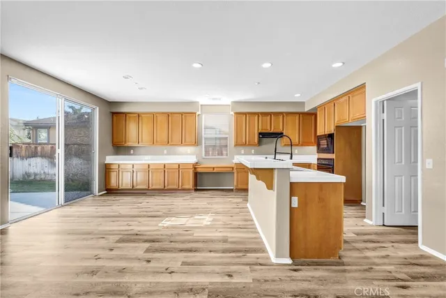 a kitchen with stainless steel appliances kitchen island granite countertop a refrigerator and a sink