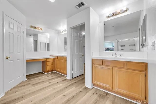 a bathroom with a double vanity sink mirror and shower