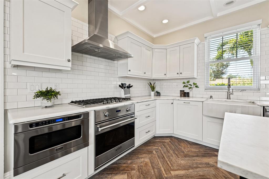 511 Windward Passage Clearwater Beach, FL 33767 - Photo 11 of 40 a kitchen with cabinets stainless steel appliances and a window