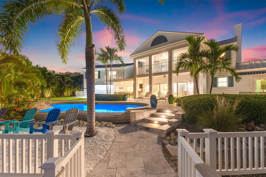 511 Windward Passage Clearwater Beach, FL 33767 - Photo 2 of 40 a view of a swimming pool with a lounge chair and palm trees