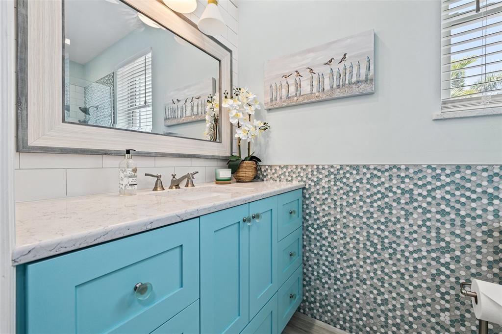 511 Windward Passage Clearwater Beach, FL 33767 - Photo 21 of 40 a bathroom with a granite countertop sink a mirror and a shower