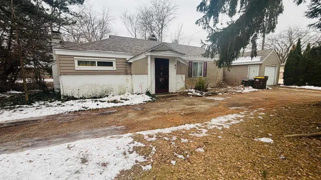 a front view of a house with a dirt road and a road