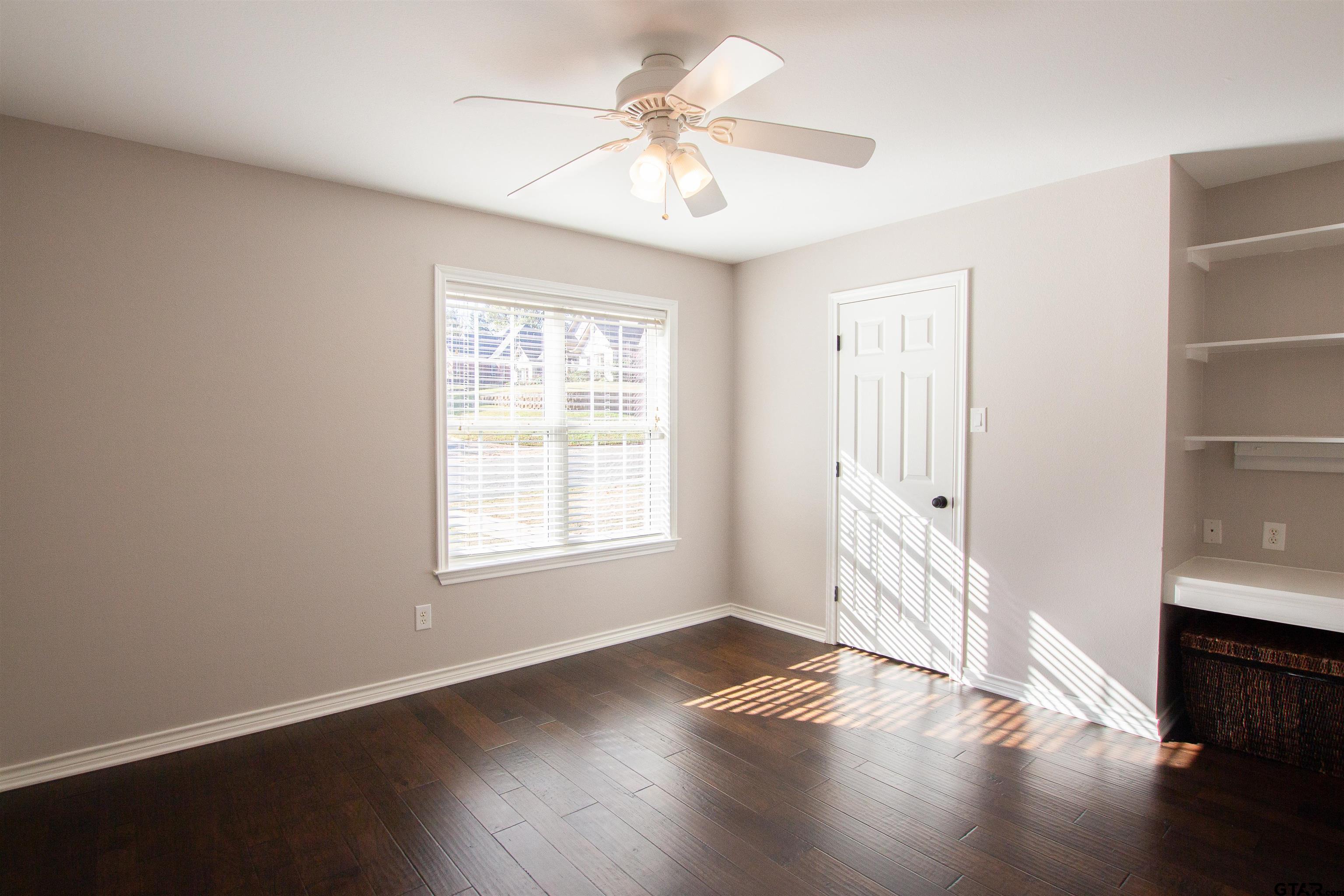 2618 Prestwick Road Jacksonville, TX 75766 - Photo 15 of 38 an empty room with wooden floor and windows