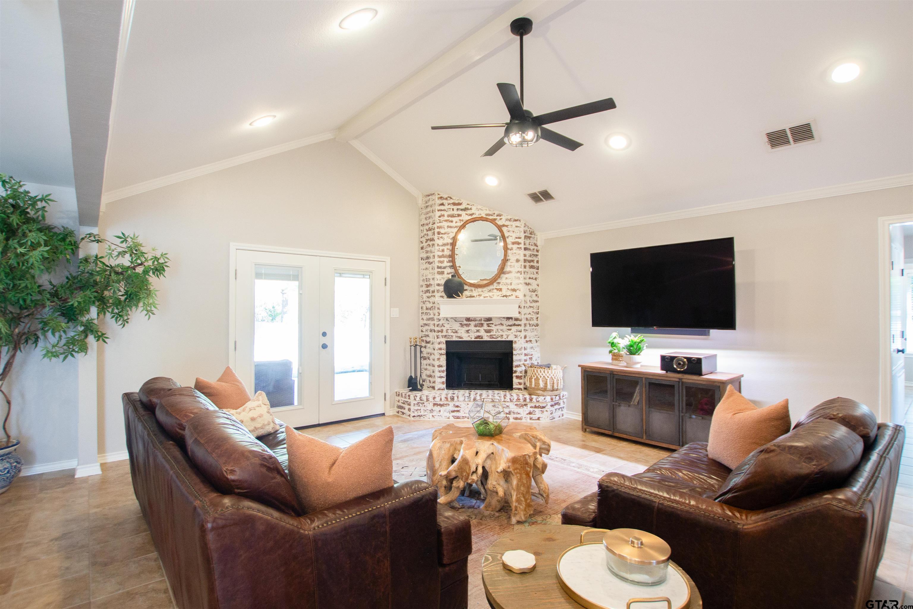 2618 Prestwick Road Jacksonville, TX 75766 - Photo 4 of 38 a living room with furniture a fireplace and a flat screen tv