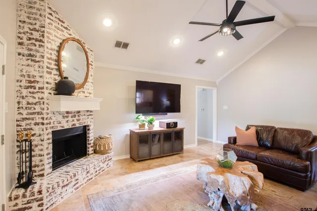 a living room with furniture a flat screen tv and a fireplace