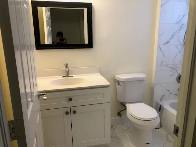 a bathroom with a toilet sink and mirror