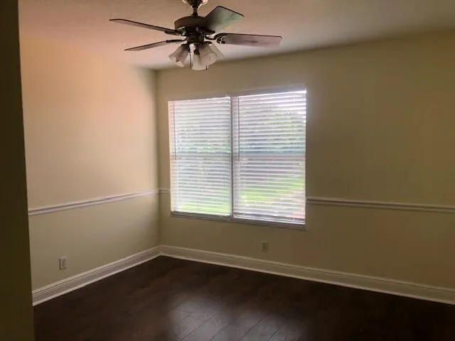 en empty room with wooden floor and windows