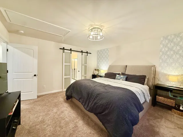 a bedroom with a bed and a refrigerator