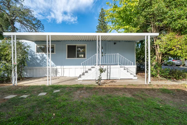 a view of a house with backyard and a tree