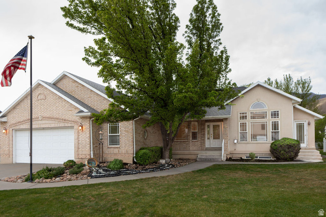 875 East 1300th Street North Mapleton, UT 84664 - Photo 4 of 65 View of front of house featuring a front lawn, an attached garage, concrete driveway, and brick siding