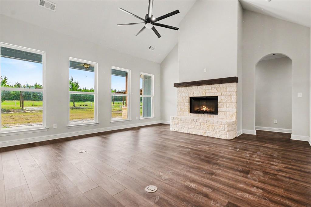 530 P R 491 Leonard, TX 75452 - Photo 9 of 35 Living area featuring a stone fireplace with a wood mantel, vaulted ceilings, and wood-finish flooring