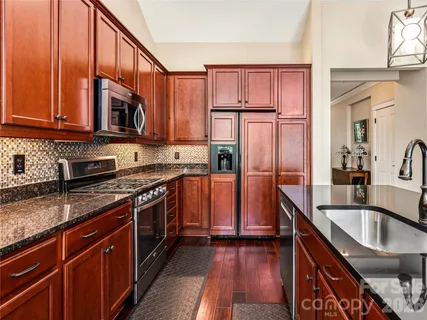 a kitchen with stainless steel appliances granite countertop a sink stove and refrigerator