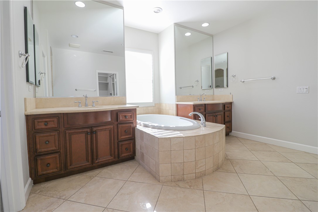 2850 North Stone Pine Glen Santa Ana, CA 92706 - Photo 29 of 45 a bathroom with a granite countertop bathtub sink and mirror