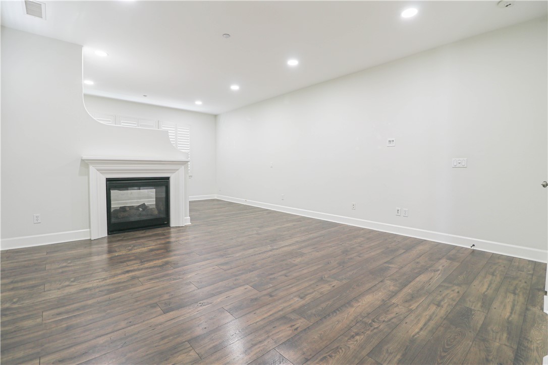 2850 North Stone Pine Glen Santa Ana, CA 92706 - Photo 32 of 45 an empty room with wooden floor and fireplace