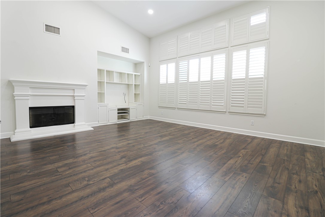 2850 North Stone Pine Glen Santa Ana, CA 92706 - Photo 39 of 45 an empty room with wooden floor fireplace and windows