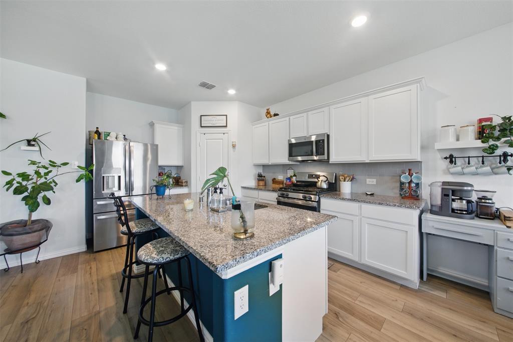 a kitchen with granite countertop kitchen island cabinets and wooden floor