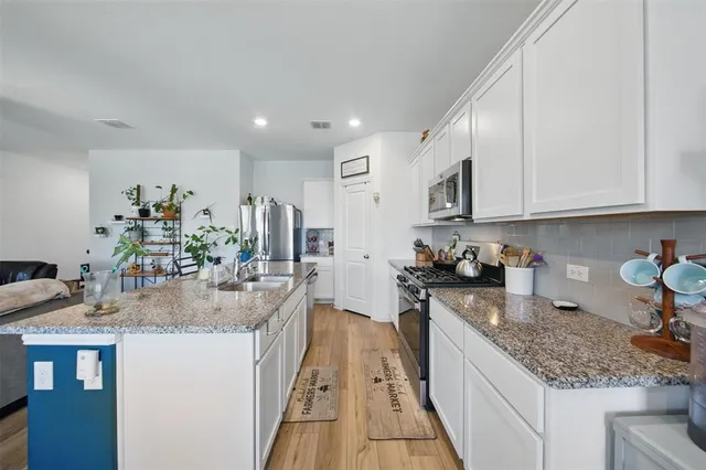 a kitchen with stainless steel appliances granite countertop a sink stove and refrigerator