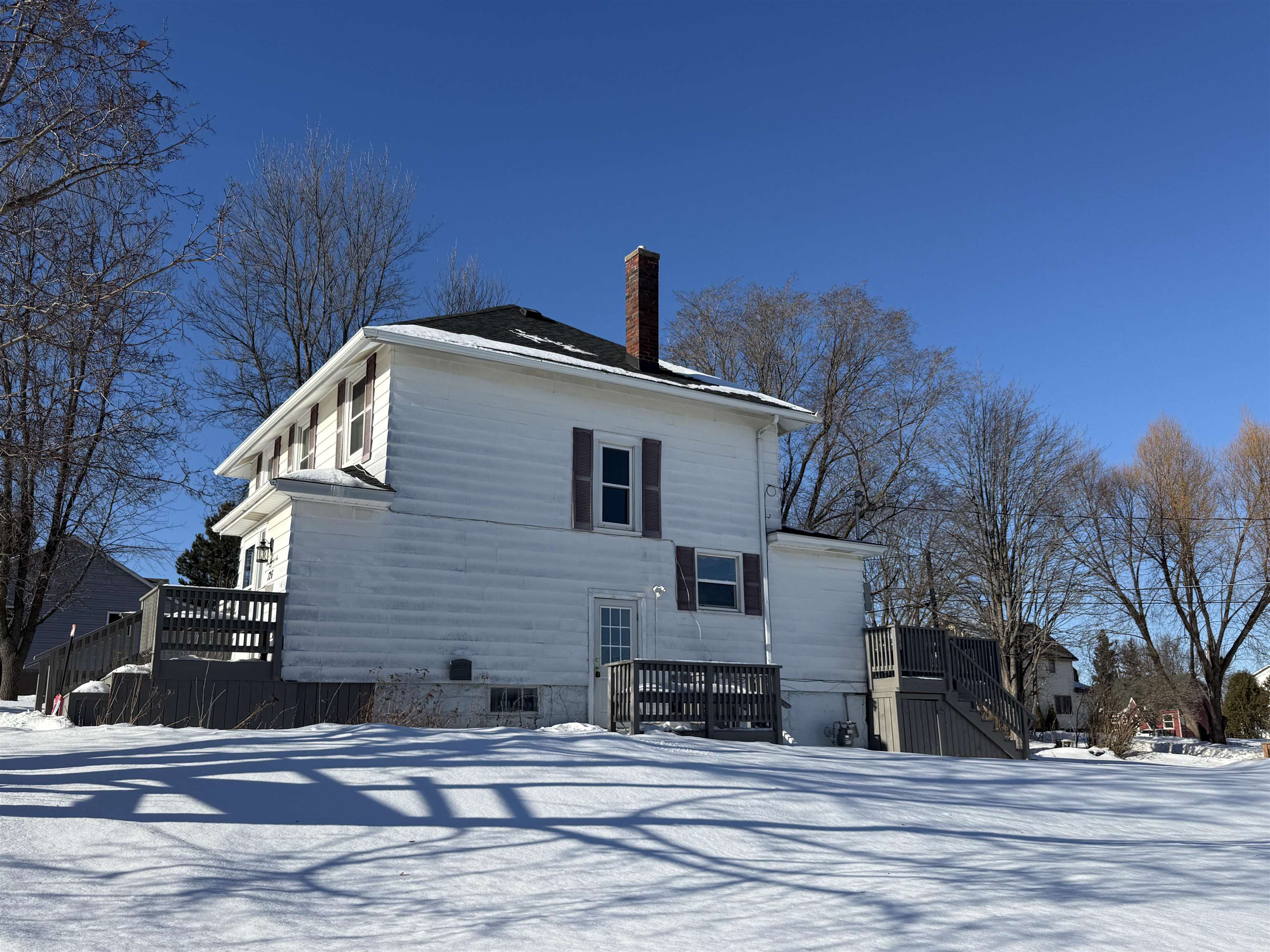 126 5th Street Northwest Chisholm, MN 55719 - Photo 2 of 35 Snow covered back of property featuring a deck, a chimney, and stairway
