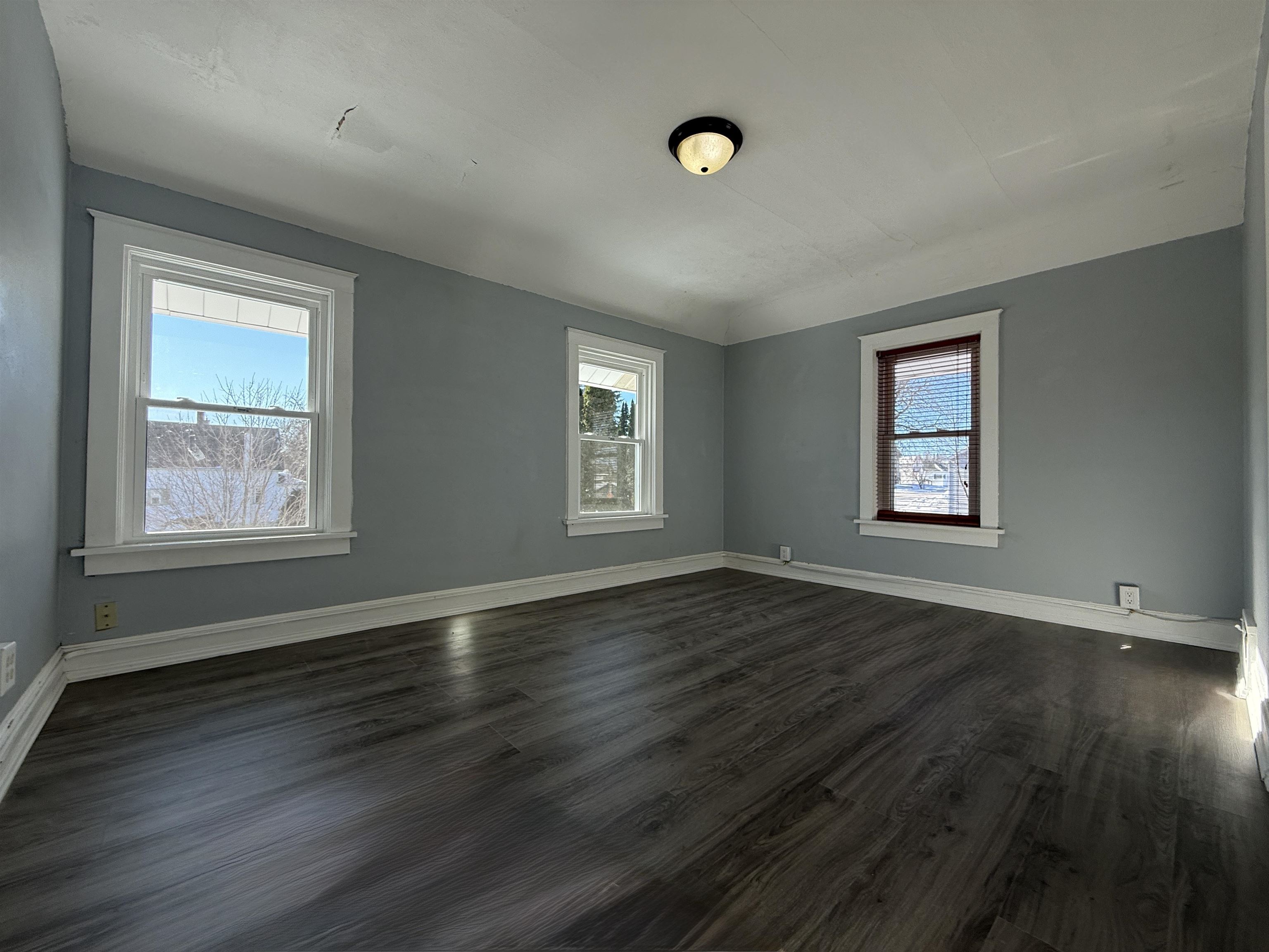 126 5th Street Northwest Chisholm, MN 55719 - Photo 25 of 35 Empty room with plenty of natural light and dark wood-style flooring
