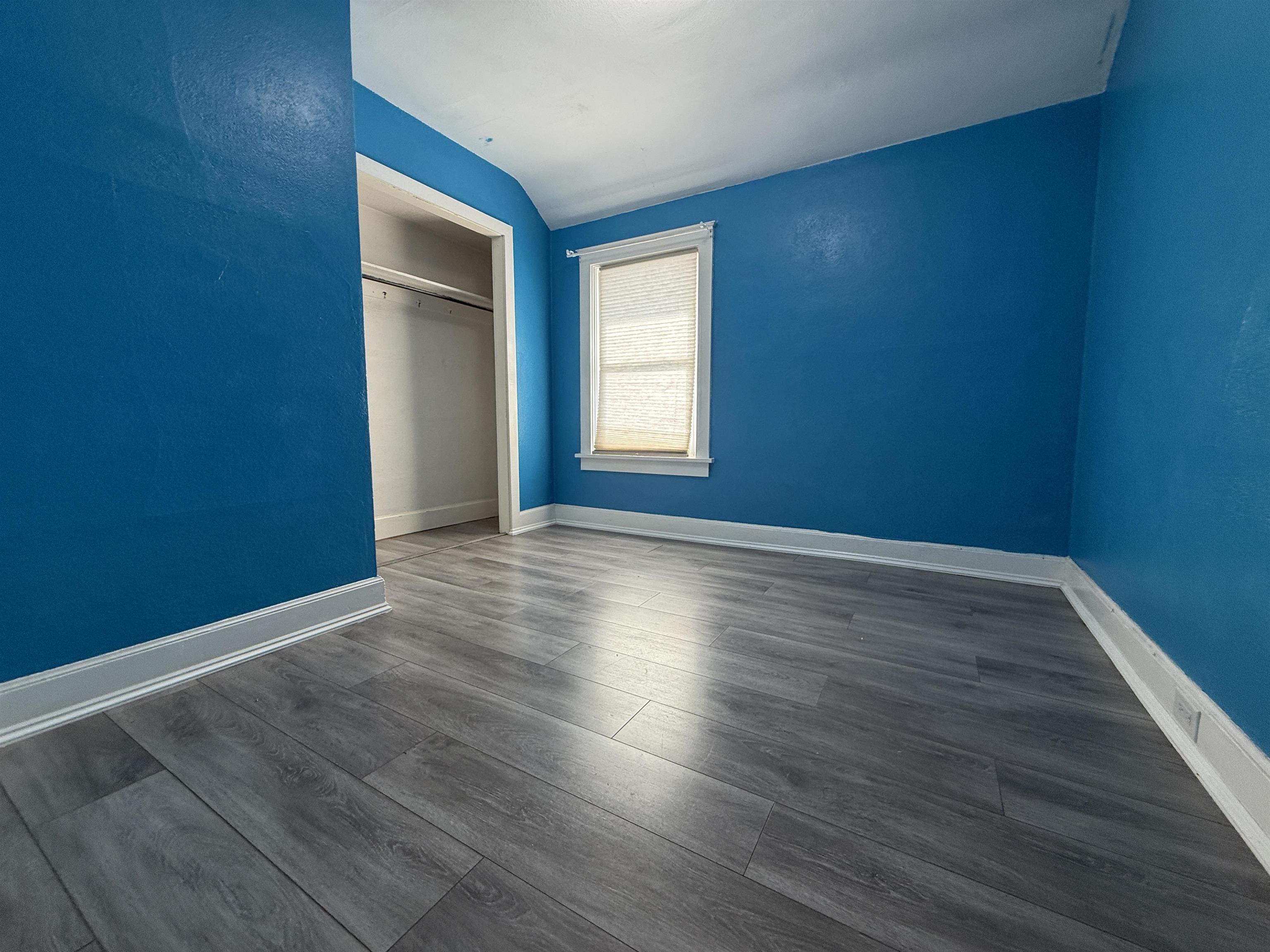 126 5th Street Northwest Chisholm, MN 55719 - Photo 26 of 35 Unfurnished bedroom featuring dark wood finished floors, a closet, and lofted ceiling
