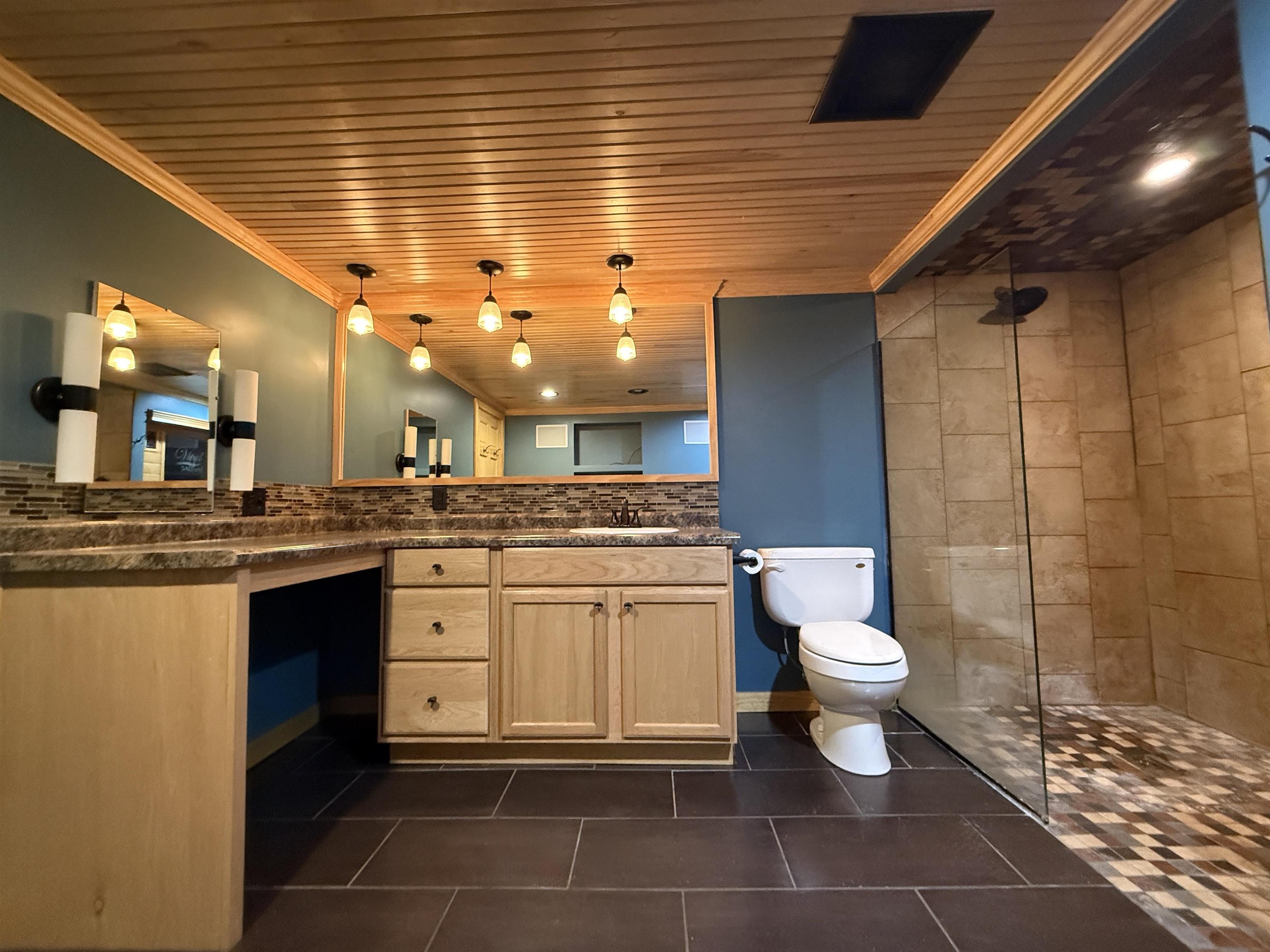 126 5th Street Northwest Chisholm, MN 55719 - Photo 32 of 35 Full bath with wood ceiling, double vanity, a walk in shower, ornamental molding, and dark tile patterned floors