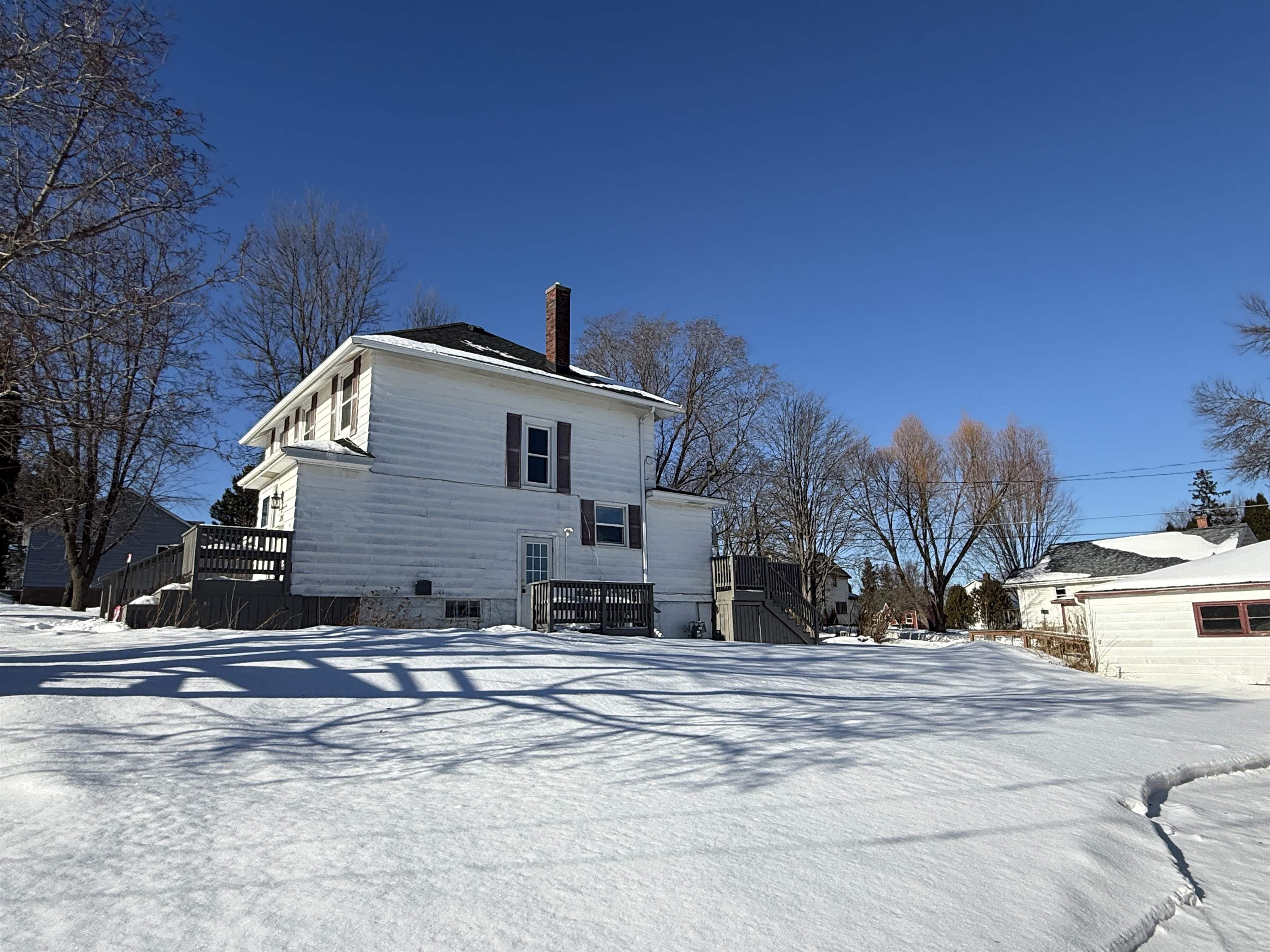 126 5th Street Northwest Chisholm, MN 55719 - Photo 35 of 35 Snow covered house with a wooden deck and a chimney