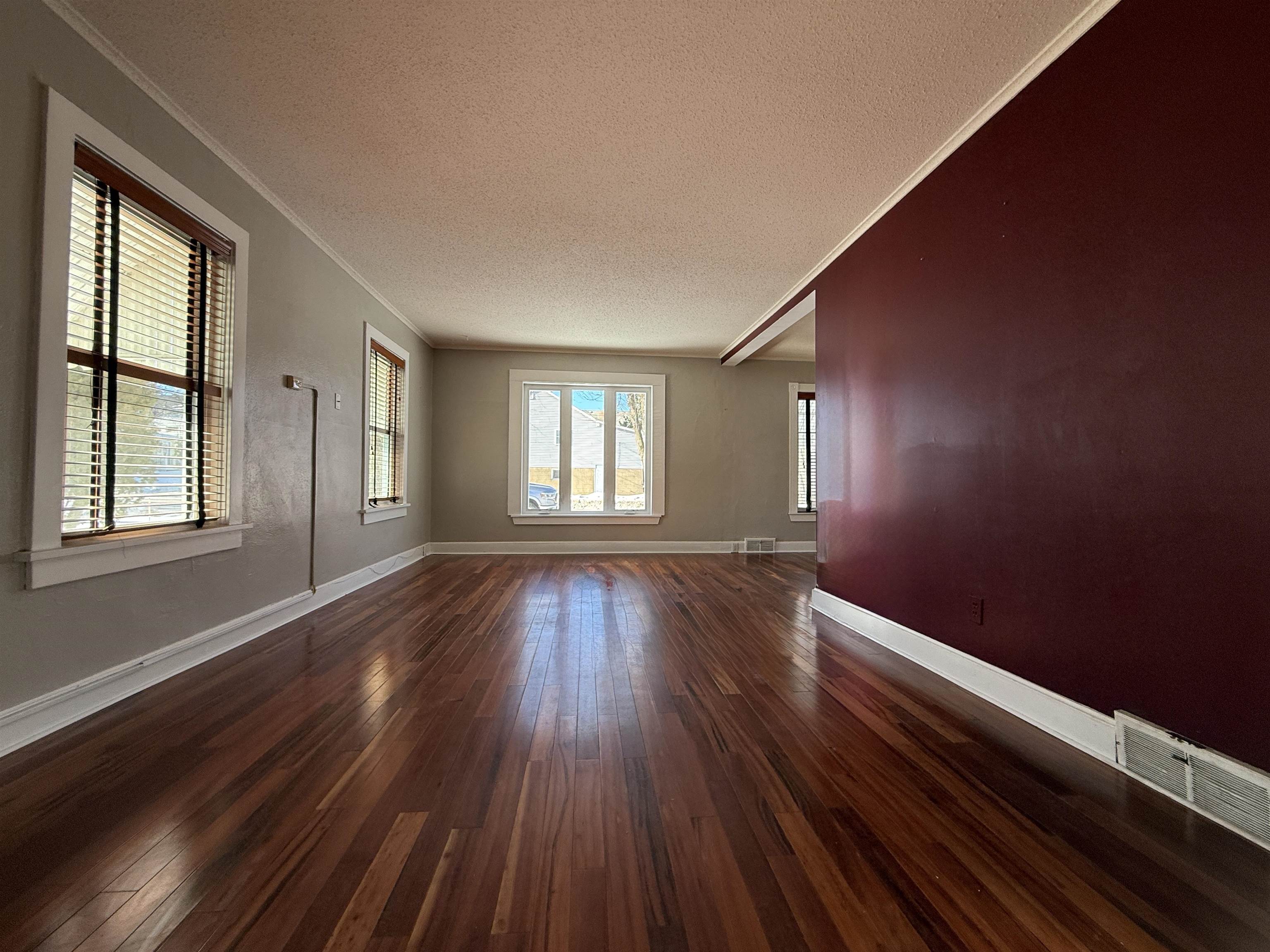 126 5th Street Northwest Chisholm, MN 55719 - Photo 8 of 35 Empty room with a textured ceiling, dark wood-type flooring, and ornamental molding