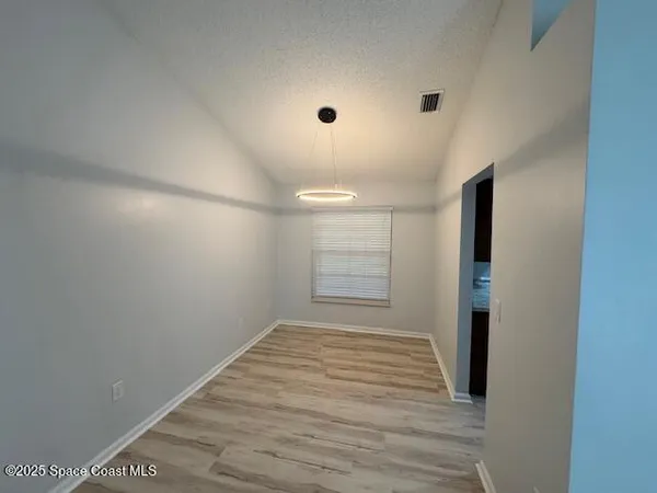 a view of a room with an empty space and wooden floor
