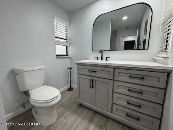 a bathroom with a toilet a sink and mirror