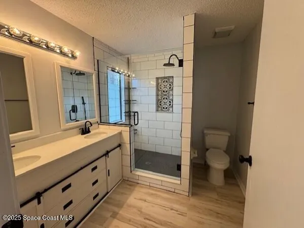 a bathroom with a double vanity sink toilet and shower