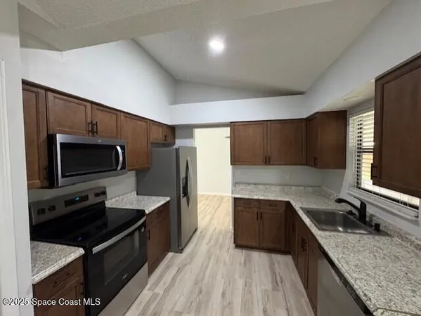 a kitchen with stainless steel appliances granite countertop a sink stove and refrigerator