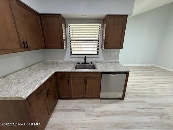 a kitchen with granite countertop cabinets sink and window