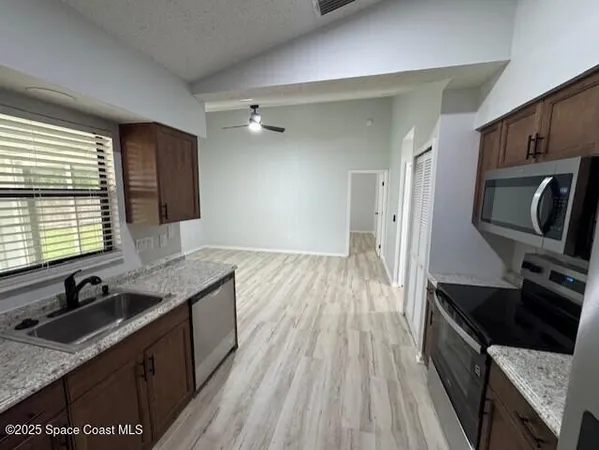 a kitchen with granite countertop a sink stove and refrigerator
