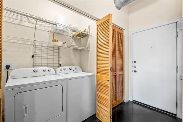 a view of washer and dryer with bathroom in the background