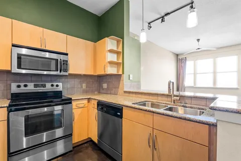 a kitchen with stainless steel appliances a stove sink and microwave